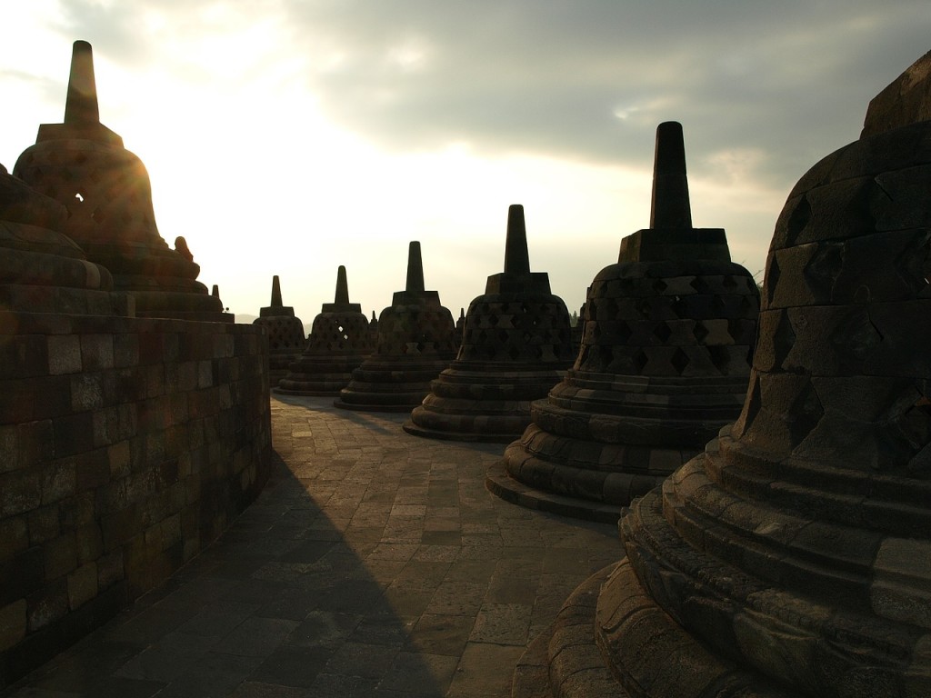Stupa dan relief candi Borobudur diterangi matahari.