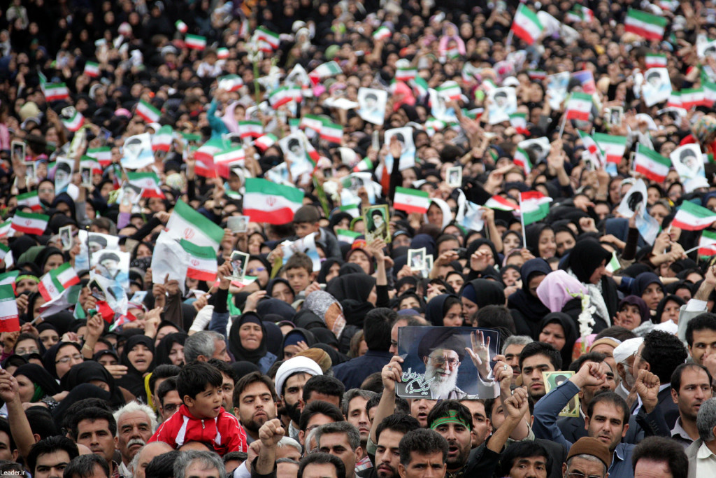Kerumunan peserta aksi mengibarkan bendera Iran.