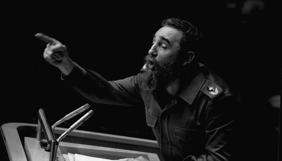 Foto hitam putih Fidel Castro berbicara di podium.