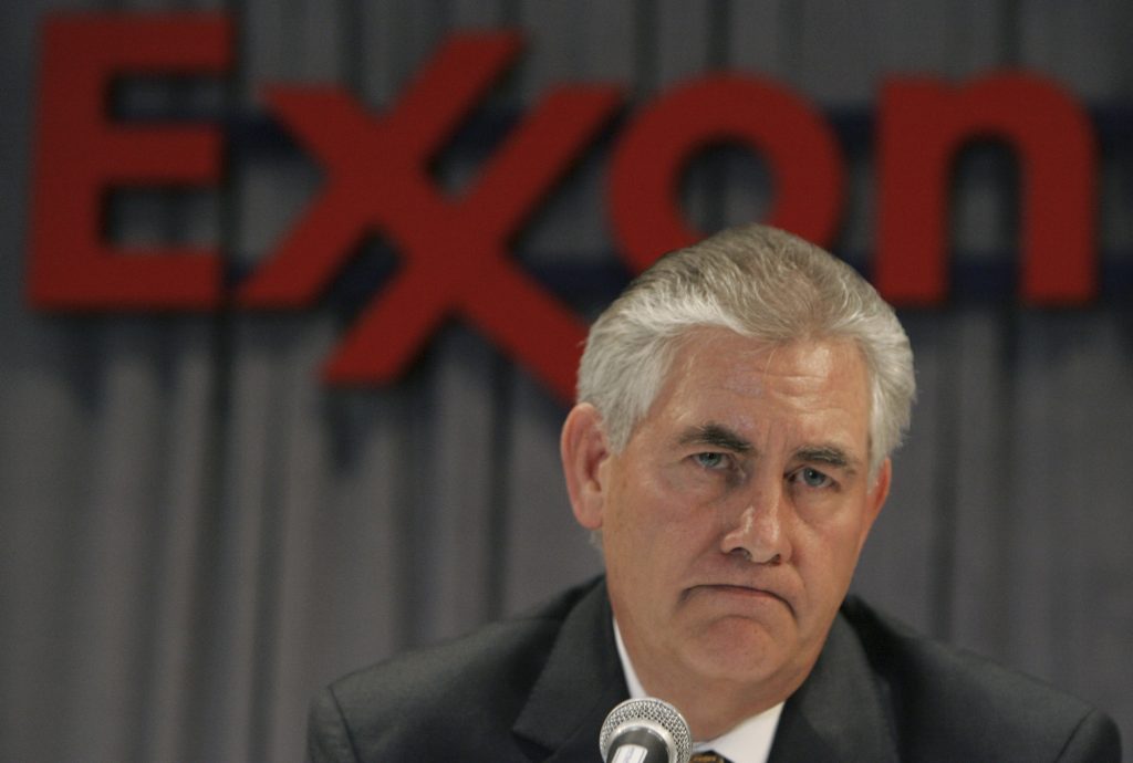 Rex Tillerson berbicara di depan logo Exxon.