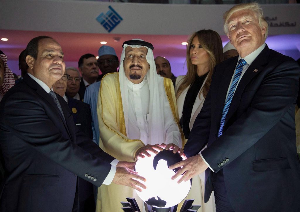Donald Trump dan para pemimpin memegang bola bercahaya dalam pertemuan.