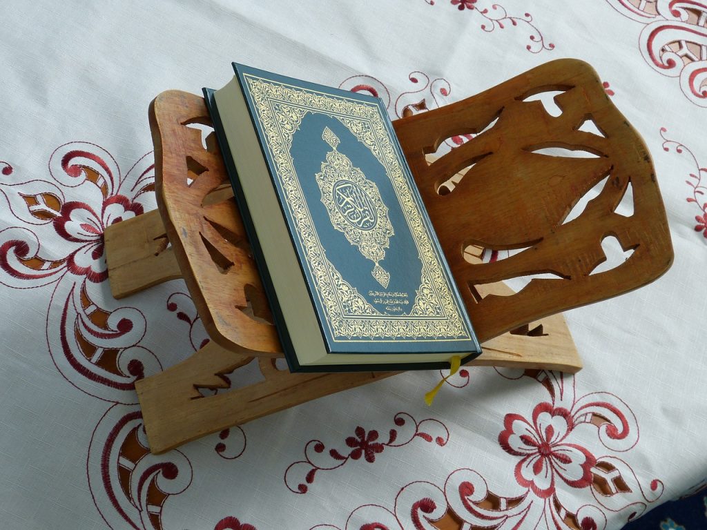 Al-Quran terbuka pada penyangga kayu.