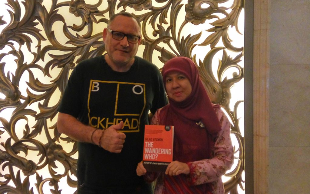 Dua orang berpose sambil memegang buku.