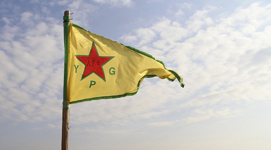 Bendera kuning bertuliskan YPG berkibar.