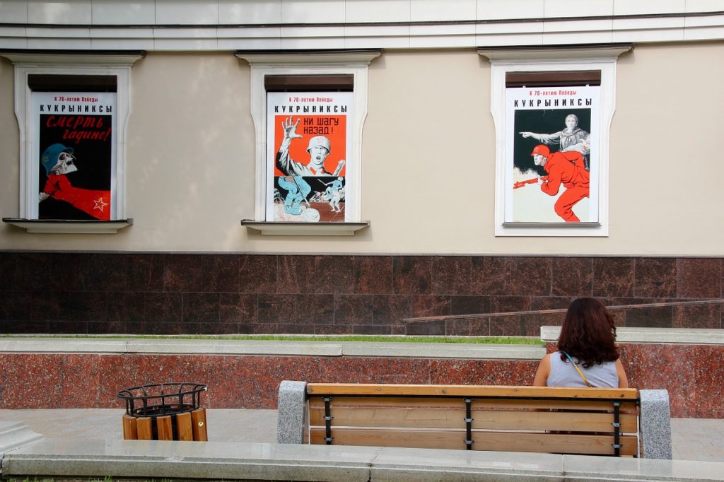 Poster-poster merah dipajang pada dinding gedung.