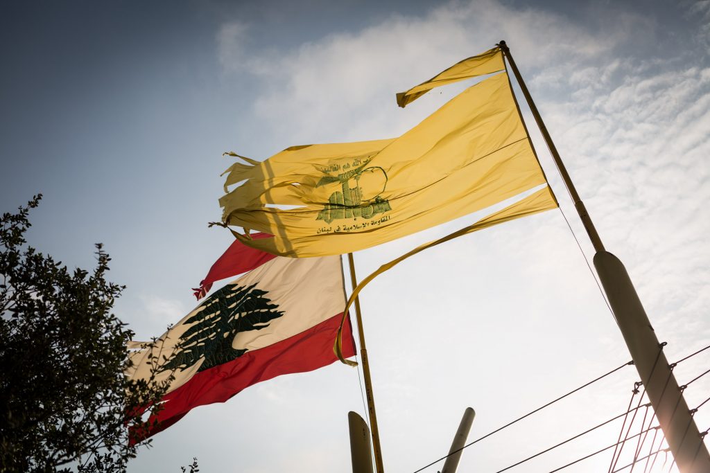 Bendera Lebanon dan bendera kuning berkibar bersama.